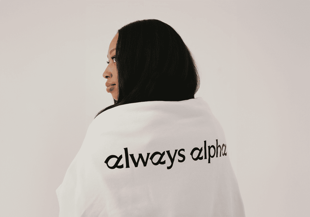 Allyson Felix back turned wearing a sweater with Always Alpha on the back