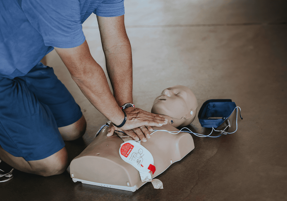 Someone practicing CPR on a dummy. 