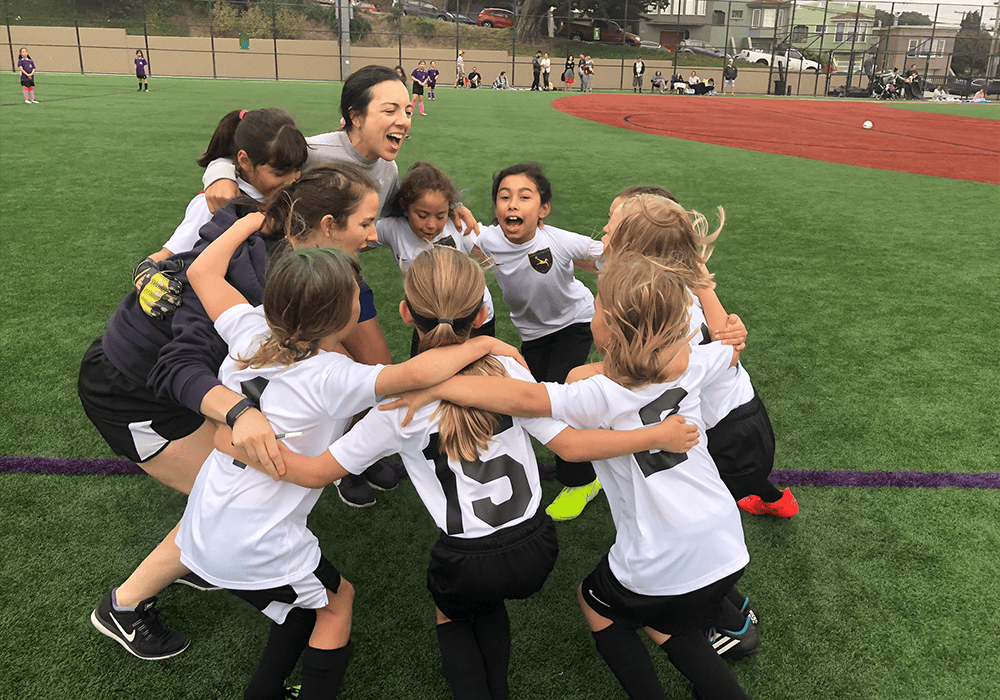 Girls Leading Girls participants in a huddle smiling.