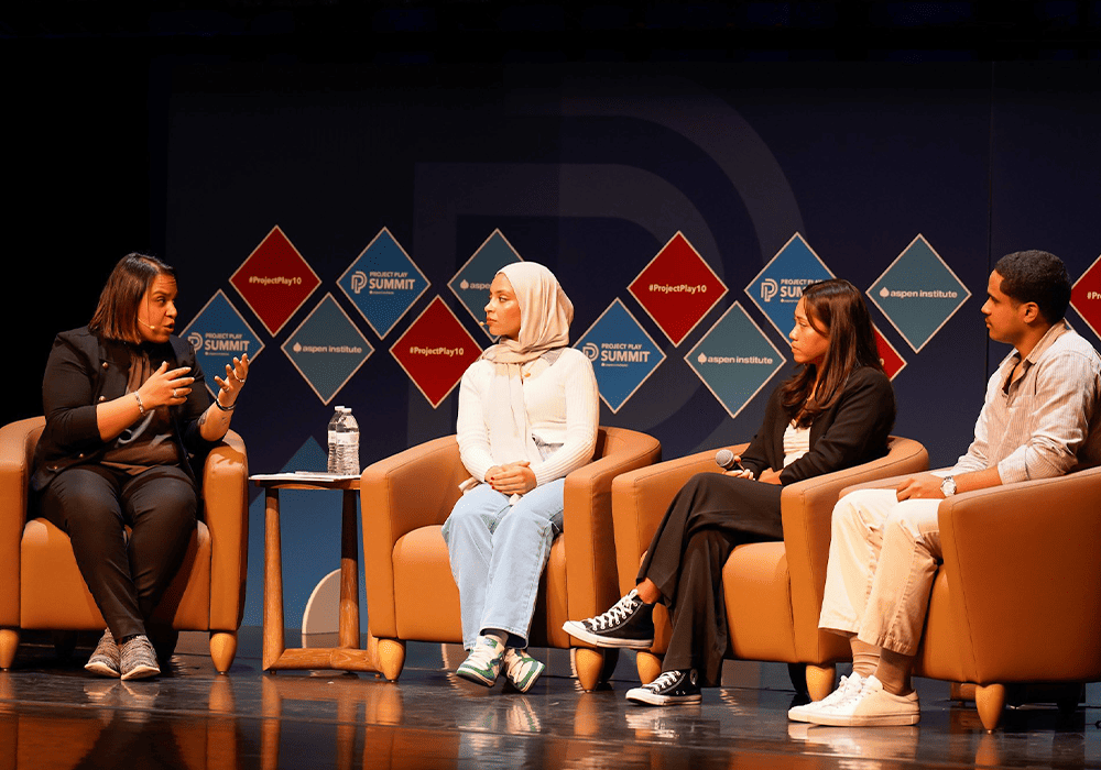 Four people participating in a panel discussion at the Project Play summit featuring young leaders.